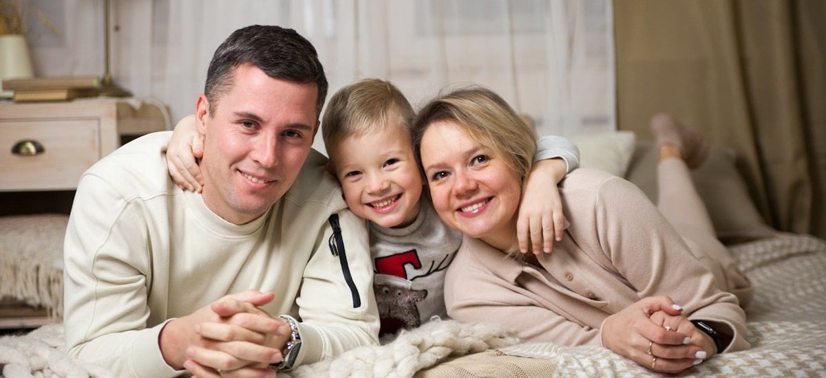 a man and woman with a couple of children on a bed